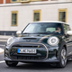 A photo of a dark green Mini Cooper SE electric car.